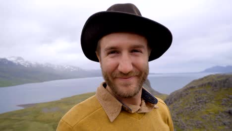 Slow-motion-video-Portrait-of-young-man-in-Iceland-near-lake-and-mountains