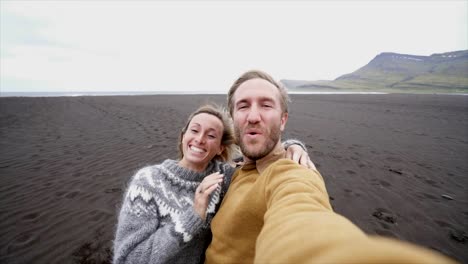 Pareja-Selfie-retrato-de-turista-en-playa-de-arena-negra-en-Islandia---cámara-lenta