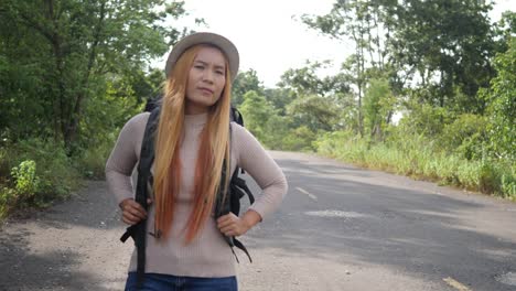 Traveler-woman-backpacker-hitchhiking-on-the-road-and-walking.