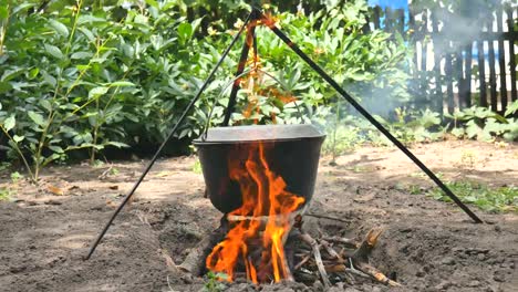 Der-Topf-mit-Wasser-hängt-über-dem-Feuer.-Das-Wasser-kocht.-Close-up