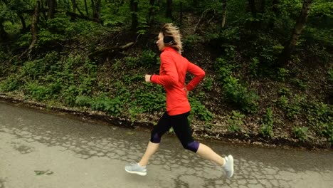 Running-girl.-Blonde-girl-doing-outdoor-sports-in-the-summer-forest.-Side-view-slow-motion-wide-angle