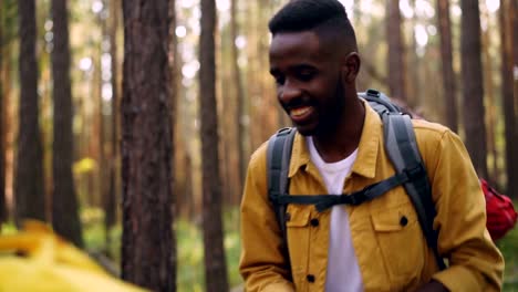 Happy-tourists-smiling-young-people-are-walking-in-forest-with-paper-map-chatting-and-laughing-enjoying-freedom-and-beautiful-nature-and-carrying-backpacks.