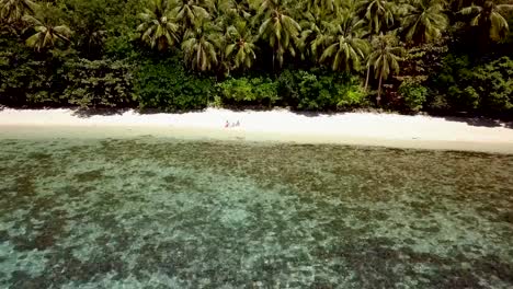 Drone-shot-aerial-view-of-Young-couple-relaxing-on-tropical-beach-in-the-Philippines-Islands.-People-travel-luxury-vacations-destinations-concept