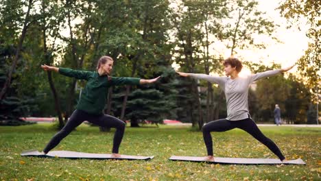 Mujeres-bonitas-es-deportes-de-moda-ropa-son-al-aire-libre-de-entrenamiento-haciendo-yoga-disfrutando-de-movimiento,-aire-fresco-y-clima-cálido-otoño.-Concepto-de-deporte-y-juventud.