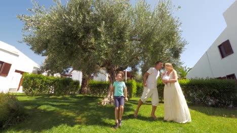 Felices-padres-con-niños-bailando-en-el-jardín