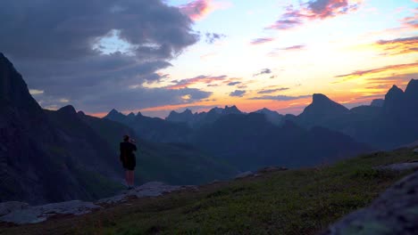 Viajero-mujer-sobre-un-fondo-de-montañas-toma-fotos-en-un-teléfono-móvil