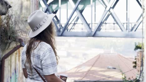 Mujer-joven-con-sombrero-caminando-en-la-calle-vieja-de-Porto