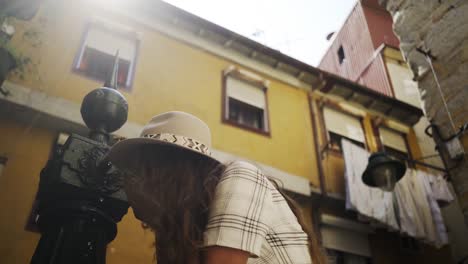 Chica-sombrero-chapoteando-en-calle-fuente