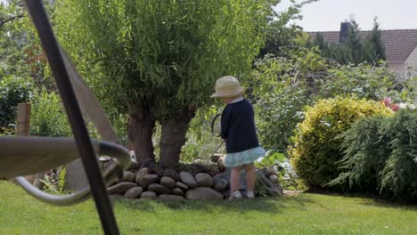 Kind-spielt-mit-Gießkanne-im-Hinterhof-Garten