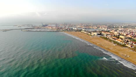 Aerial-Port-of-Valencia-from-the-altitude.-Flight-over-the-sea-in-the-direction-of-the-port.-Panorama-of-the-port-in-Valencia,-Spain,-Europe