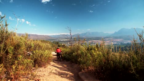 Mountain-biker-Reiten-auf-eine-cross-country-Schotterstrecke