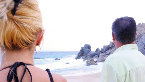 An-older-couple-looking-out-at-the-ocean,-close-up-from-behind