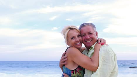 Portrait-of-an-older-couple-hugging-and-smiling-at-the-beach