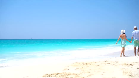 Joven-pareja-en-la-playa-durante-vacaciones-de-verano.-Los-amantes-de-disfrutan-de-su-luna-de-miel-feliz.