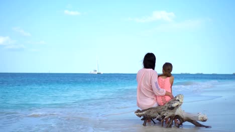 Familia-de-la-madre-y-la-niña-en-la-playa-tropical