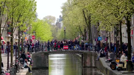 Menschen-gehen-und-stehen-auf-der-kleinen-Brücke-über-den-Kanal