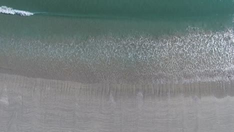 Aerial-Shot-of-Wave-Break-and-Beach-Walkers