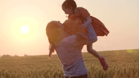 young-Asian-family-in-a-field-with-a-baby-1-year-on-hand,-the-concept-of-family-happiness,-beautiful-sunlight,-sunset,-slow-motion