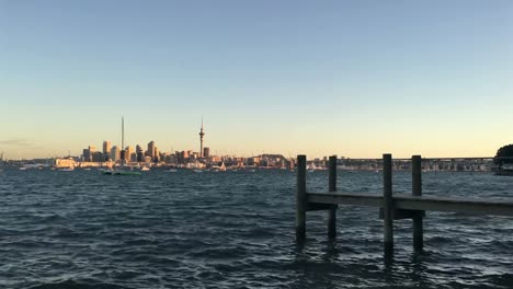 Auckland-city-skyline-New-Zealand-with-an-empty-wooden-pier-at-sunset