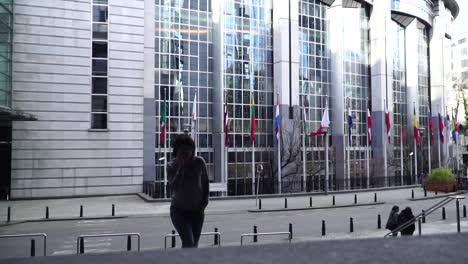 lady-is-walking-and-talking-on-the-phone-near-the-European-Parliament-in-Brussels.-Belgium.-slow-motion