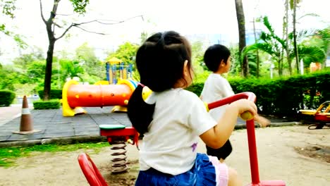 Un-niño-y-una-niña-están-jugando-en-el-patio-de-recreo-en-el-parque-por-la-tarde,-jugar-con-felicidad-y-alegría.