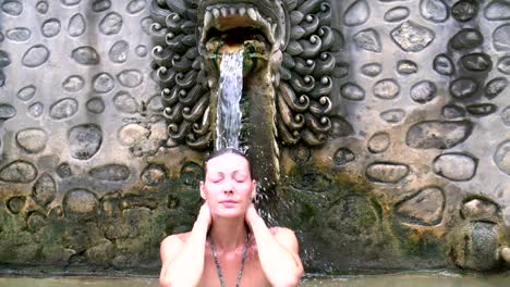 Eine-Frau-steht-unter-dem-Strahl-des-Mineralwasser