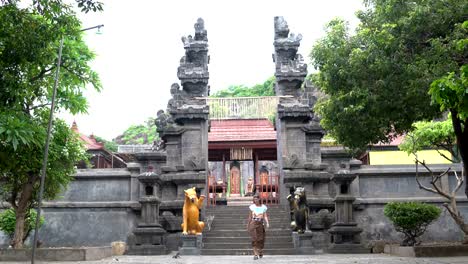 A-woman-in-a-long-skirt-descends-the-steps-of-a-Buddhist-temple