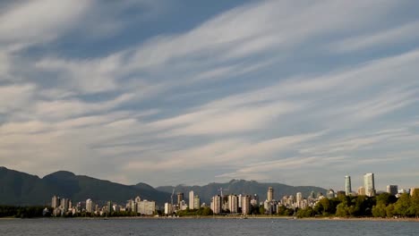 high-rise-buildings-of-modern-seaside-city,-yachts-and-ships,-from-the-ocean-side-against-the-background-of-mountains