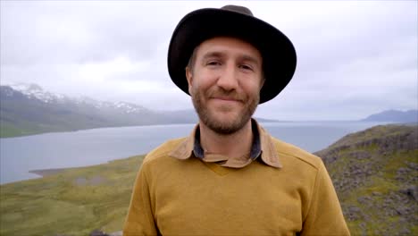 Slow-motion-video-Portrait-of-young-man-in-Iceland-near-lake-and-mountains