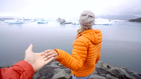 Follow-me-to-concept,-young-woman-leading-boyfriend-to-glacier-lagoon-in-Iceland