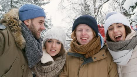 Happy-Friends-Waving-at-Camera-Outdoors-at-Winter-Day