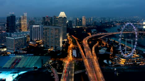 Time-lapse-day-to-night-of-Singapore-Flyer,-the-ferris-wheel,-and-skyscraper-buildings-in-financial-district,-downtown-Singapore-City