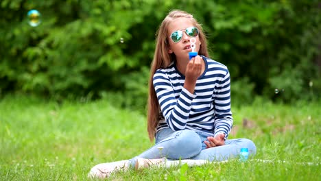 Niña-jugando-con-pompas-de-jabón-al-aire-libre.-Cámara-lenta.