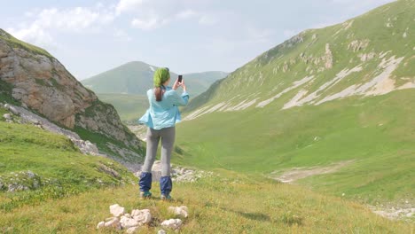 Hiker-woman-enjoy-beautiful-mountain-landscape-and-make-photo-to-mobile-phone