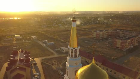 Aerial-Nahaufnahme-Religion-Kreuz-auf-erstaunliche-golden-Kirchenarchitektur-während-des-Sonnenuntergangs