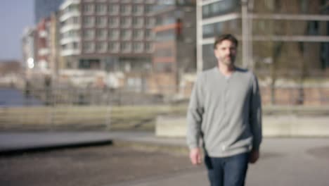 Middle-aged-man-walking-towards-the-camera-in-urban-hamburg-city.