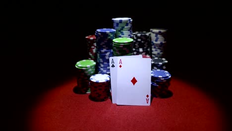 Teo-aces-and-stack-of-gambling-chips-on-red-casino-table