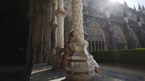 Young-woman-sitting-near-pillars-of-old-building