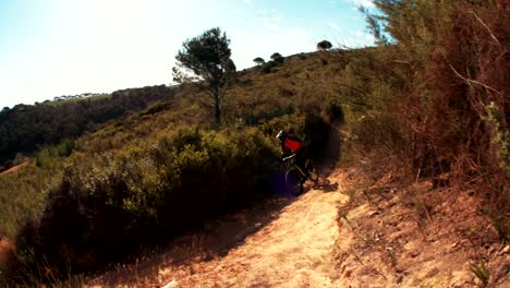 Mountain-biker-riding-a-singletrack-cross-country-trail-in-mountains