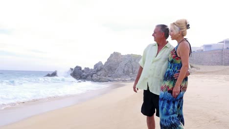 Una-Pareja-de-ancianos-mirando-hacia-fuera-del-mar-cuando-las-olas-Échales-sobre-ellas