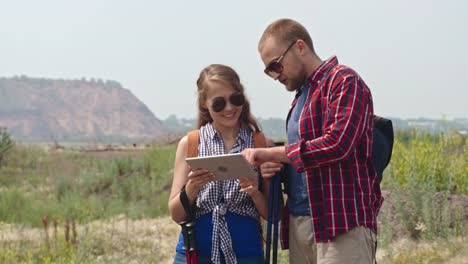 Pareja-mirando-tableta-en-viaje-de-trekking