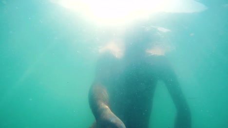 Underwater-shot-of-a-man-swimming-in-the-sea