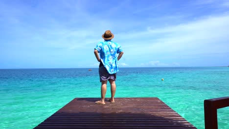 woman-sitting-at-ocean-deck-turn-back-to-camera-happy