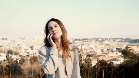 Retrato-de-joven-bella-mujer-en-la-vista-panorámica-de-Roma,-Italia.-Mujer-hablando-por-el-teléfono-inteligente