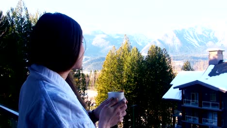 Mujer-que-tiene-una-taza-de-café-en-el-balcón