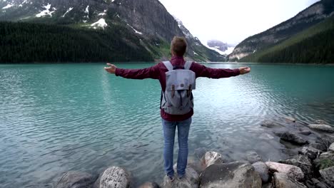 Junger-Mann-am-Lake-Louise-ausgestreckte-Armen