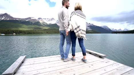 Joven-pareja-relajarse-en-el-muelle-del-lago,-caminar-y-contemplar-vistas-Canadá