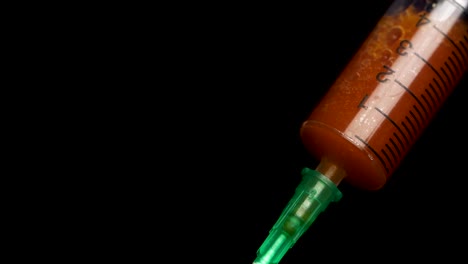 Syringe-with-blood-on-a-black-background-close-up.-The-syringe-with-the-medicine-is-close-up-ready-for-injection.-Medical-syringe-filled-with-red-liquid