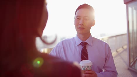 Multi-ethnic-business-consultants-enjoying-coffee-on-rooftop