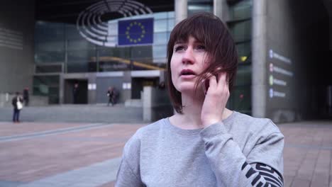 Dame-ist-Fuß-und-am-Telefon-in-der-Nähe-des-Europäischen-Parlaments-in-Brüssel.-Belgien.-Slow-motion